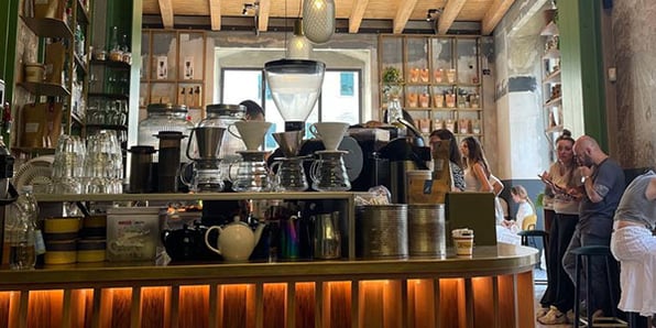The counter of a coffee shop with lots of pots and cups arranged on it